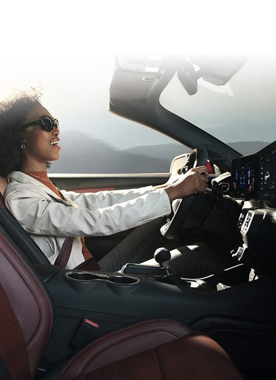 Person sitting in the driver’s seat of a 2024 Ford Mustang® convertible | Essential Ford of Stuart in Stuart FL